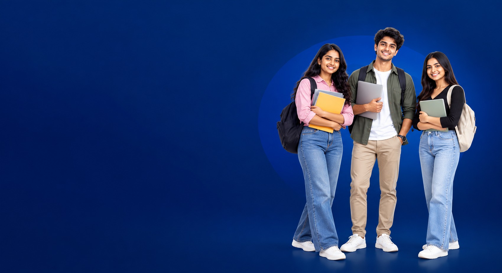 Three smiling students holding books and a laptop